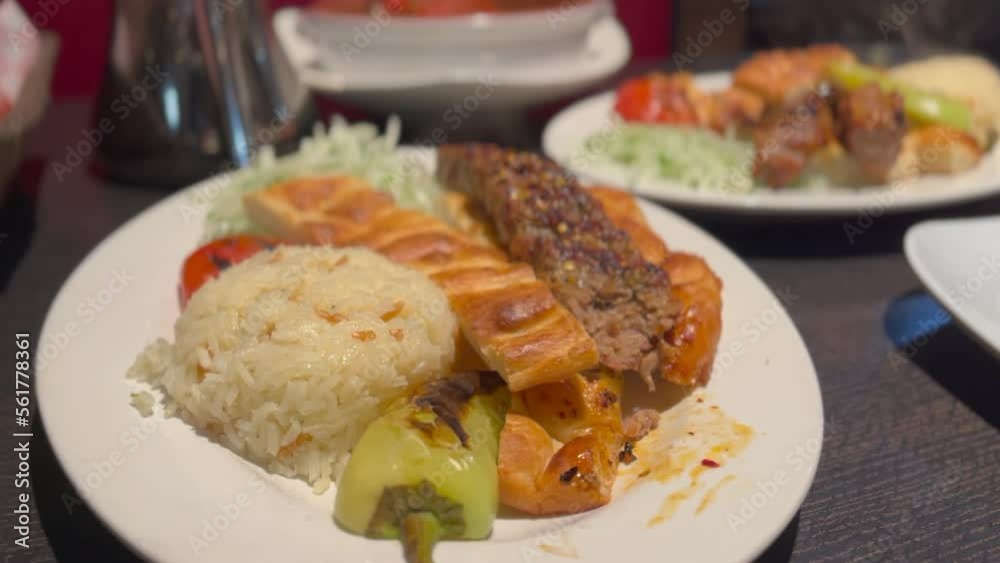 An HD shot of Turkish kabob, an halal dish of skewered and grilled meat, being eaten with a fork. The meat appears to be juicy and tender, with a slightly charred exterior. An HD shot of Turkish kabob, an halal dish of skewered and grilled meat, being eaten with a fork. The meat appears to be juicy and tender, with a slightly charred exterior.