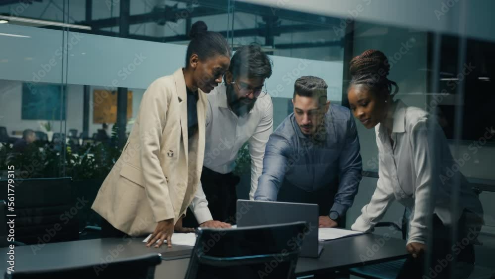 Multiracial business team group of workers developers managers looking at laptop in office celebrating success victory good news put palms up partnership unity gesture good investment financial profit