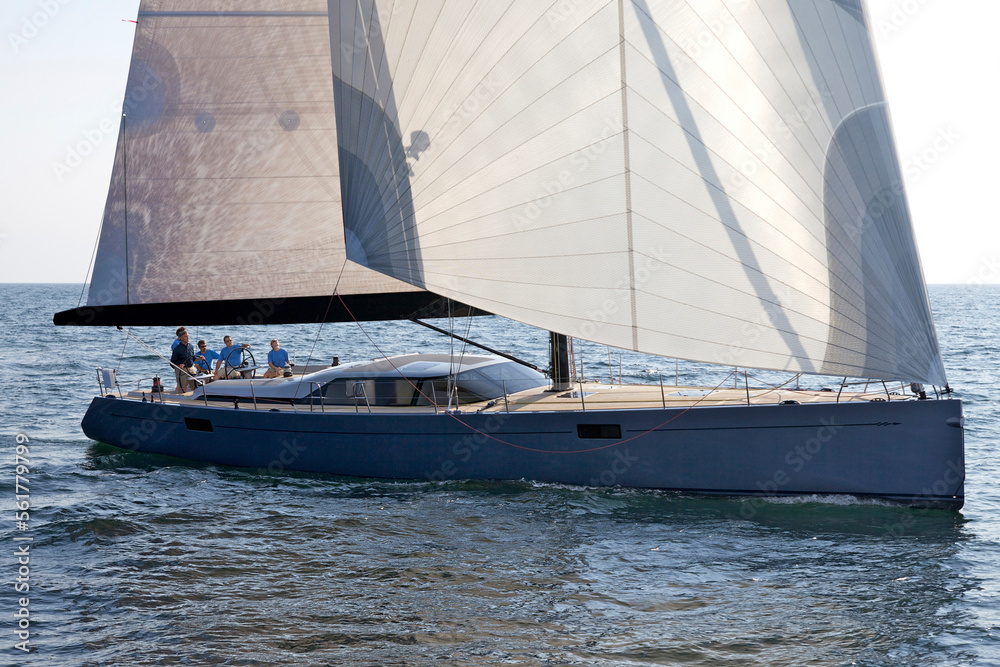 A crew races a modern ocean-going sailing yacht. A crew races a modern ocean-going sailing yacht.