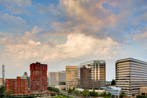 Clouds drift over a line of office buildings late on a summer afternoon. photo