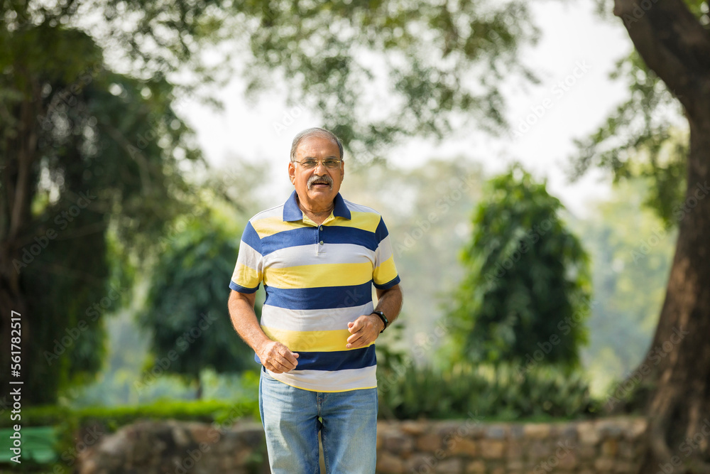 Fototapeta premium Indian old man running or jogging at park