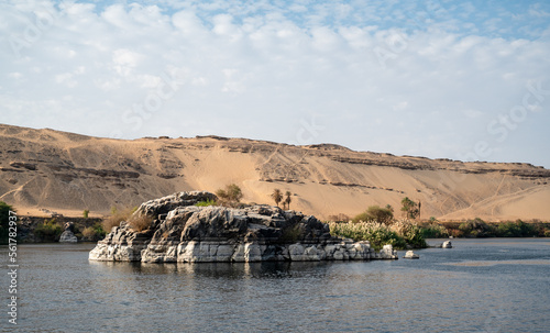 Rock in the middle of Nile river with the desert in the back, Egypt