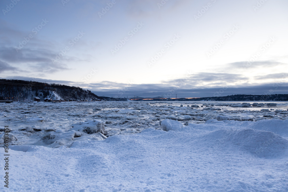 Pretty view of the St. Lawrence river, the Cap-Rouge bay, and the Pierre-Laporte and Quebec bridges in the distance seen during a blue hour winter morning, Quebec City, Quebec, Canada