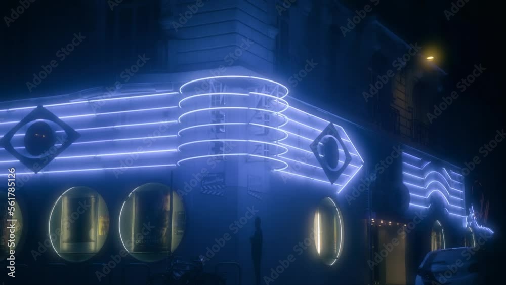 bus driving by old retro vintage cinema with blue neon signs