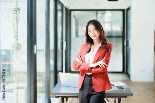 Portrait of a woman business owner showing a happy smiling face as he has successfully invested her business using computers and financial budget documents at work