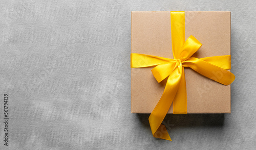 Beautiful gift box with golden ribbons on a gentle light background.
