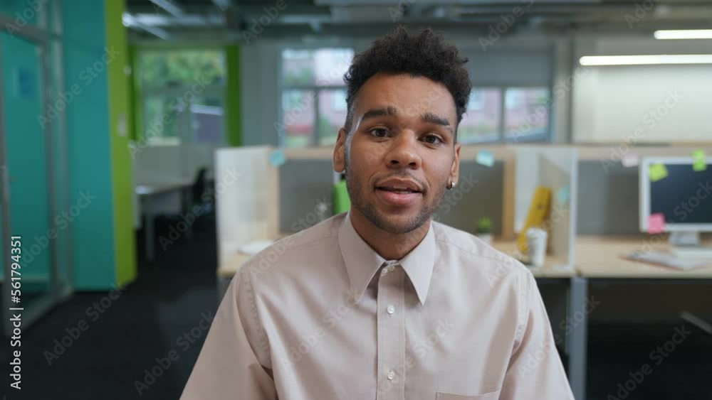 Portrait of a cheerful art director against the background of international office space, man looks at the camera and communicates by video call, open space. Portrait of a cheerful art director against the background of international office space, man looks at the camera and communicates by video call, open space.