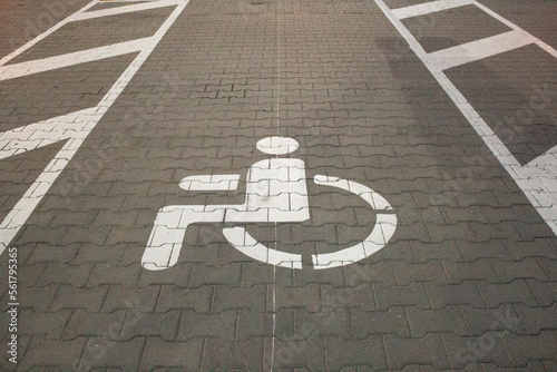 White sign of a parking lot for disabled people on a road