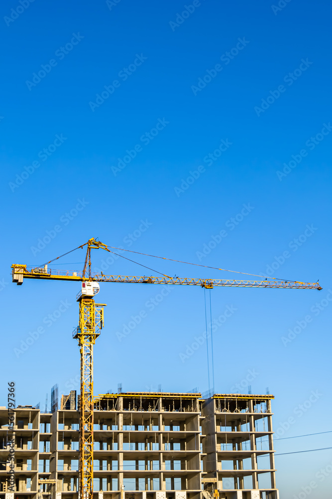 Big steel crane on construction site of residential building