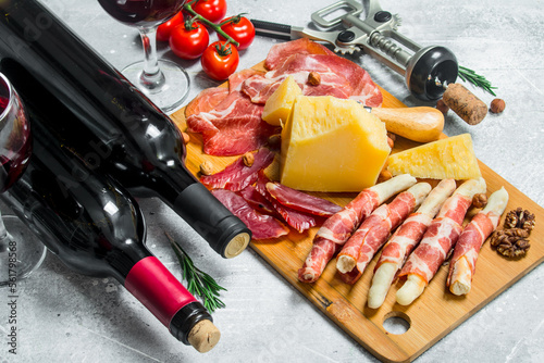 Antipasto background. Various meat and cheese snacks with red wine.