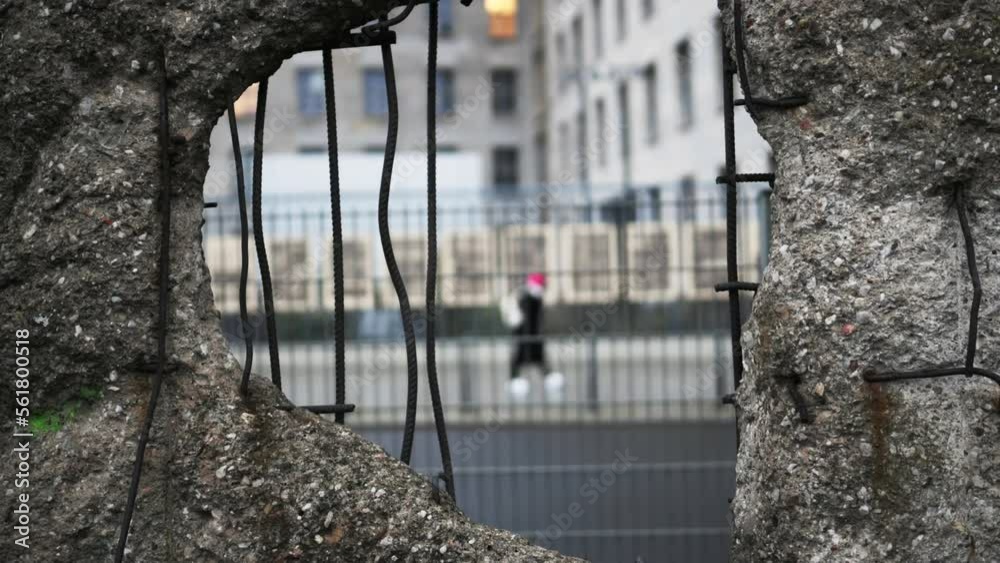 Hole in Broken Berlin wall and walking person against. Concept of freedom and independence. Hole in Broken Berlin wall and walking person against. Concept of freedom and independence.