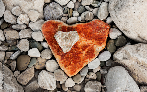 Rotes Steinherz auf einem Fels mit Kieselsteinen