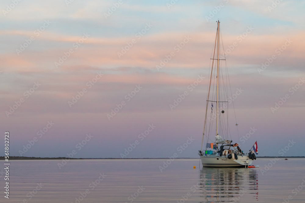 Fototapeta premium Sailing boat anchored with dramatic sunset