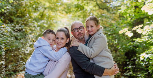 Portrait of happy family with kids in a forest. © Halfpoint