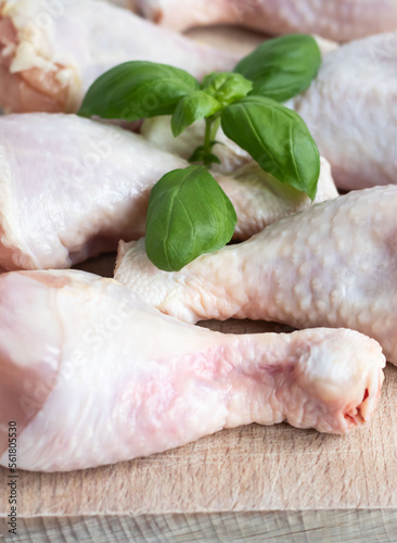 Raw chicken legs. On a white background. Salt, pepper, leaves