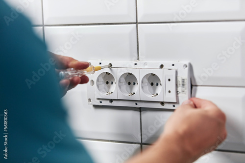 Electrician repairing and fixing wires in the electrical socket. photo