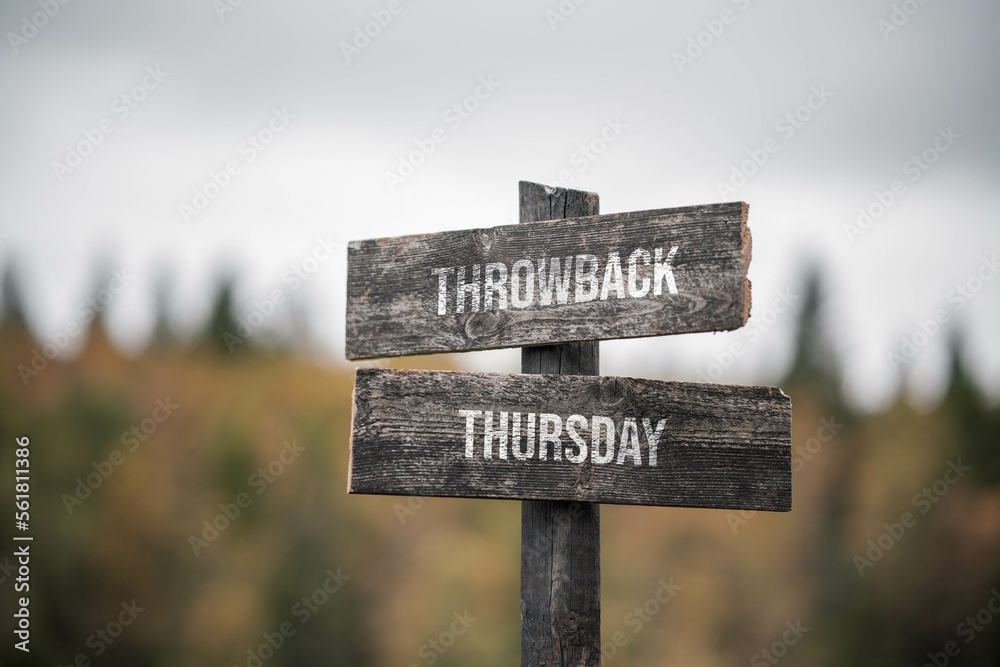 vintage and rustic wooden signpost with the weathered text quote throwback thursday, outdoors in nature. blurred out forest fall colors in the background.