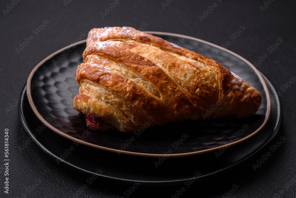 Delicious fresh crispy bun with jam on a black ceramic plate Delicious fresh crispy bun with jam on a black ceramic plate