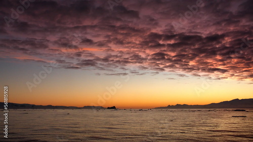 Pink popcorn clouds in an orange sky at sunset  at Cierva Cove  Antarctica