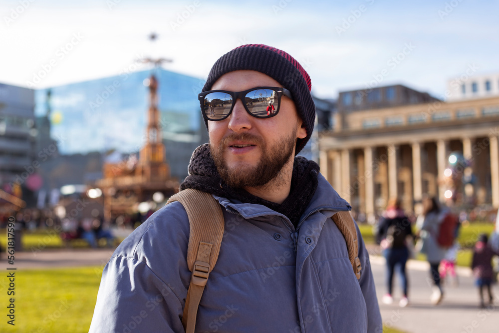 Smiling young man in sunglasses in a hat on the street Smiling young man in sunglasses in a hat on the street