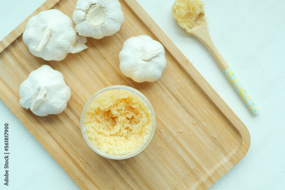 close up of minced garlic on a wooden spoon close up of minced garlic on a wooden spoon