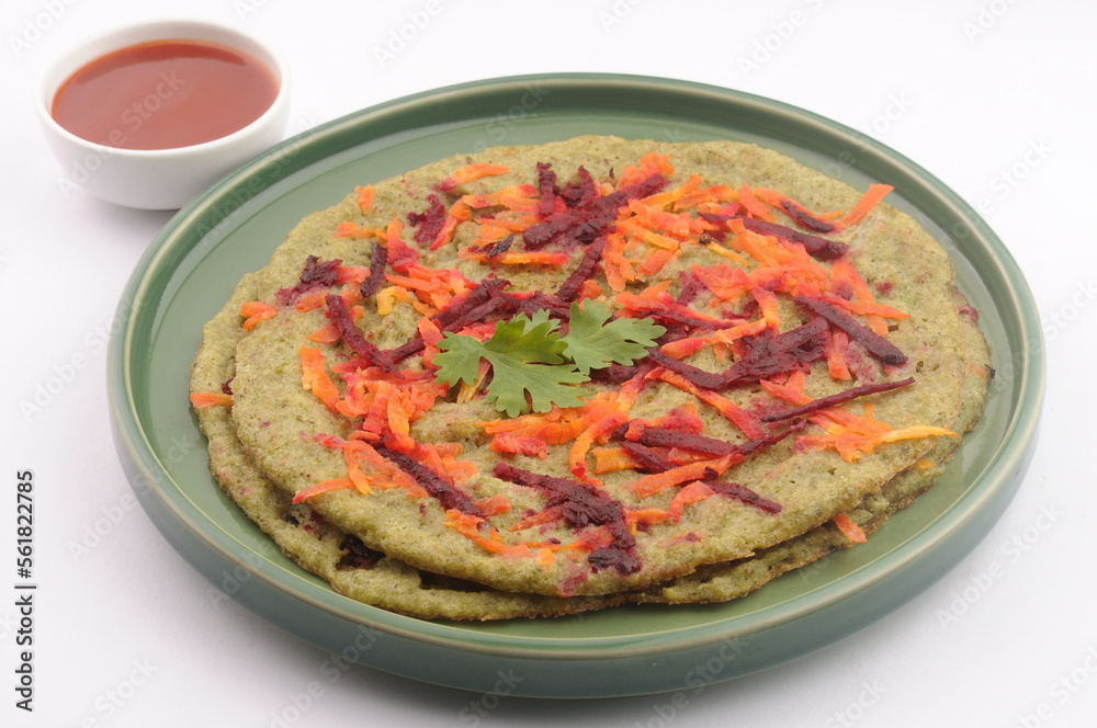 Pesarrattu or green dosa made from green moong dal and rice, garnished with grated beetroot and carrot, a healthy south Indian dosa Pesarrattu or green dosa made from green moong dal and rice, garnished with grated beetroot and carrot, a healthy south Indian dosa