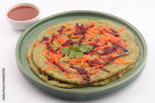 Pesarrattu or green dosa made from green moong dal and rice, garnished with grated beetroot and carrot, a healthy south Indian dosa