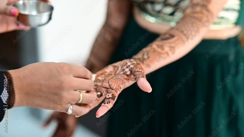 Apply lemon juice and oil on henna tattoo on hands close up for colors. Bridal mehendi in
