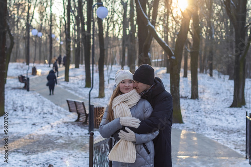 guy hugging his girlfriend from behind in winter park
