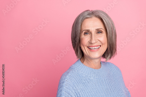 Photo of cheerful stunning elderly lady wear blue knitted clothes demonstrate empty space clothes isolated on pink color background