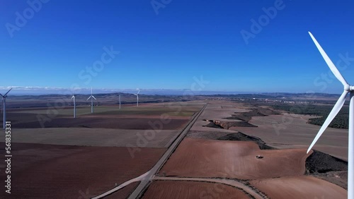 long secondary road between wind turbines and fields