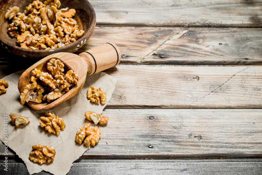 Peeled walnut in a wooden scoop . Peeled walnut in a wooden scoop .