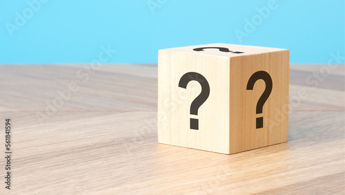 cube with question mark on wooden background, closeup © Maks_Lab