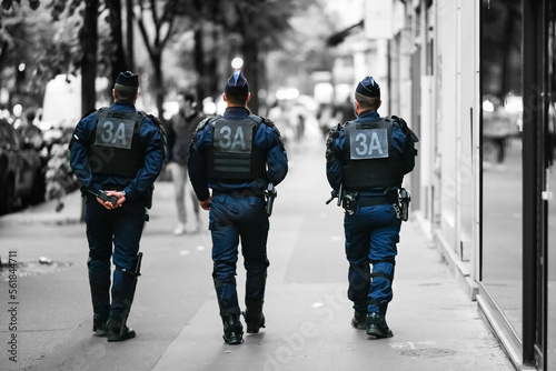 Fototapeta Naklejka Na Ścianę i Meble -  Police officers (CRS) walk the streets with uniform ensuring security in Paris, France. French national policemen in action.