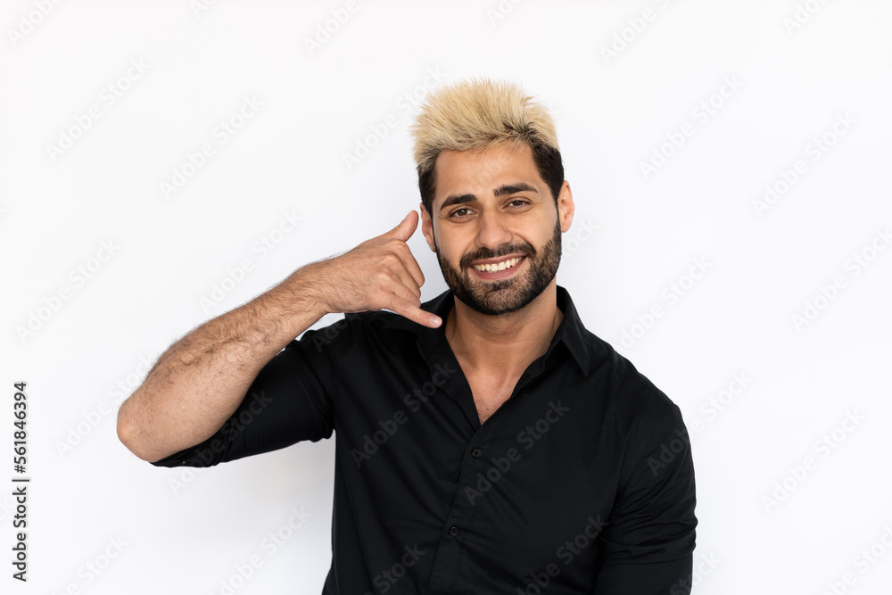 Portrait of playful young man making phone gesture. Male Caucasian model with brown eyes, ombre painted hair and beard in black shirt smiling showing call me back sign. Coquetry, advertisement concept Portrait of playful young man making phone gesture. Male Caucasian model with brown eyes, ombre painted hair and beard in black shirt smiling showing call me back sign. Coquetry, advertisement concept