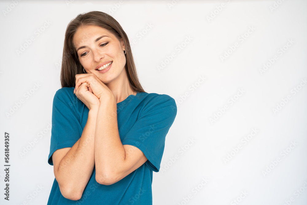 Pleased Caucasian woman leaning on hands. Portrait of happy young female model with brown hair in blue T-shirt looking down, smiling, reacting to something cute. Kindness, memory concept Pleased Caucasian woman leaning on hands. Portrait of happy young female model with brown hair in blue T-shirt looking down, smiling, reacting to something cute. Kindness, memory concept