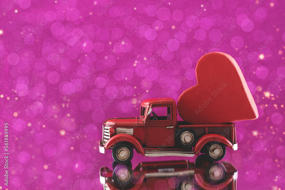 The toy car carries the heart. Valentine's day concept.