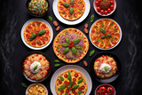 Full table of italian meals on plates Pizza, pasta, ravioli, carpaccio. caprese salad and tomato bruschetta on black background. Top view. Generative AI