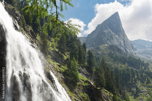 beautiful waterfall in the high tauern massive with the gruebelwand in the background during a beautiful summer hike.
