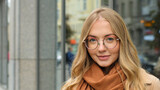 Close up female portrait outdoors 20s Caucasian woman wearing eyeglasses and scarf looking at camera girl blonde model 30s millennial lady with glasses posing on street city attractive student outside