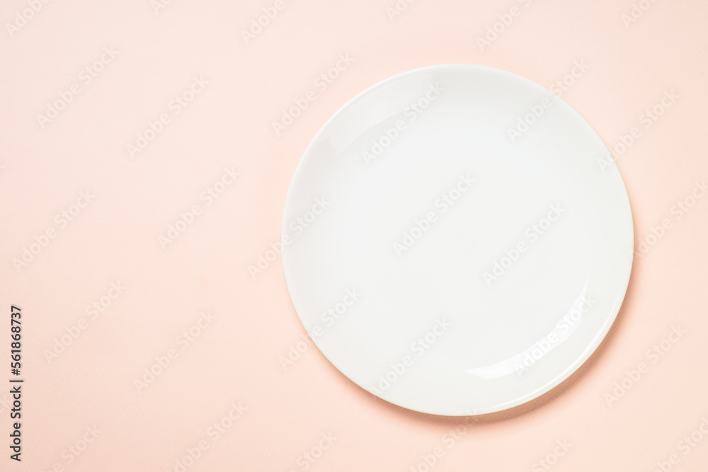 White plate at pink background. Top view with copy space. White plate at pink background. Top view with copy space.
