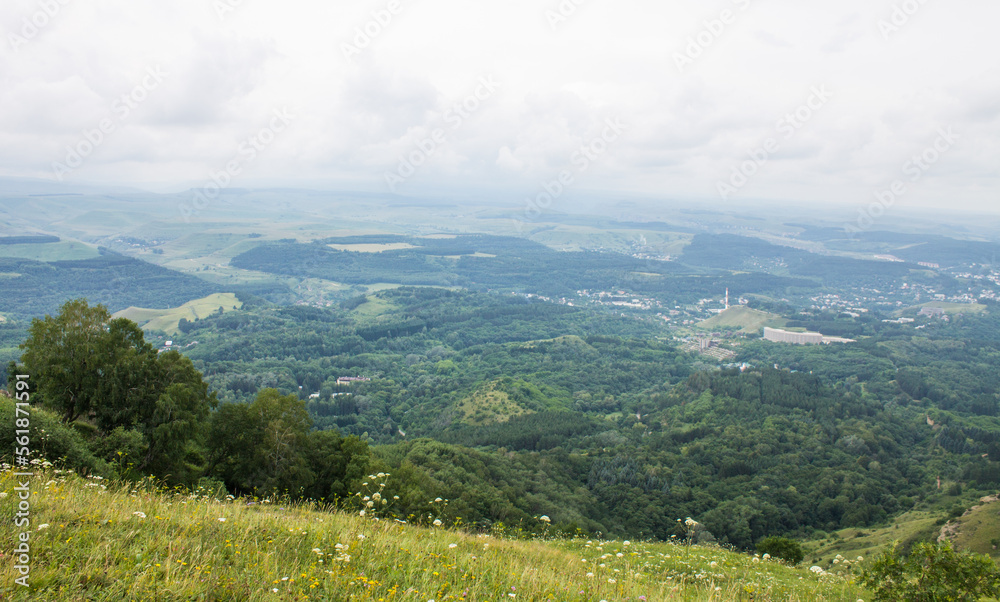 panorama of green hills and valleys in a hazy haze on the horizon in Kislovodsk on a cloudy summer day and space for copying