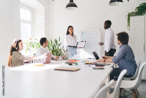 Diverse colleagues working together on business strategy in light workspace