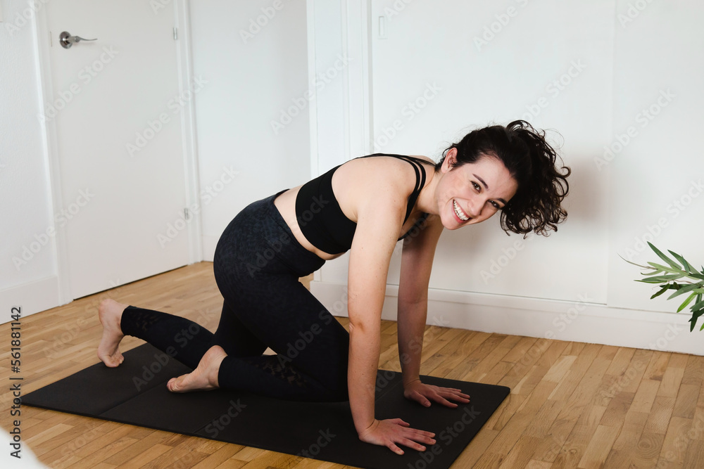 Young beautiful woman laughing at herself trying to do some fitness at home Young beautiful woman laughing at herself trying to do some fitness at home