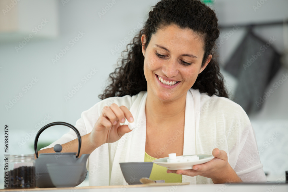 happy woman throwing sugar into mug happy woman throwing sugar into mug