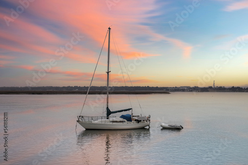 anchored sailboat with raft and solar panels at sunset © Bill Keefrey