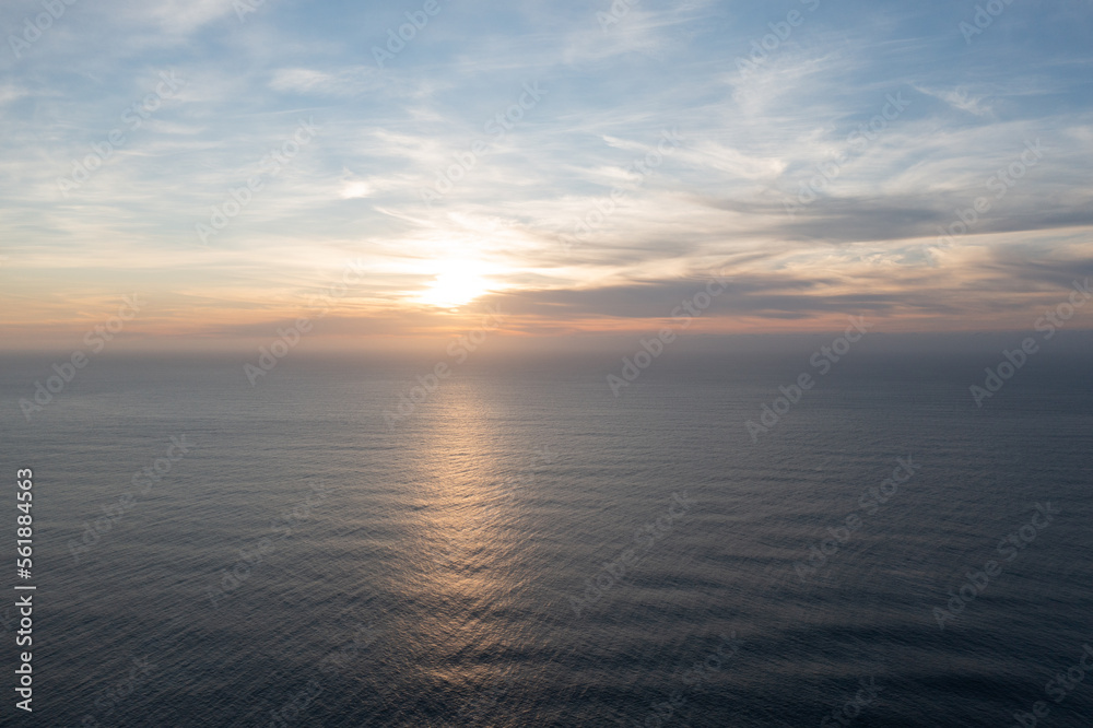 Great drone photo of a sunset over the Atlantic Ocean with a bit of cloud cover.