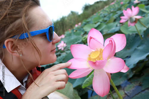 Woman touching indian lotus flower in estuary of Sea of Azov photo