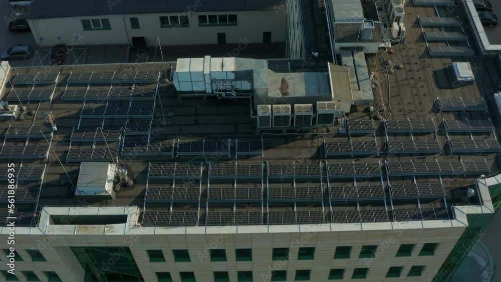 Aerial view of many solar panels installed on the roof of an apartment building. Solar panels at the top of the building. Solar modules on a flat roof. Aerial view of many solar panels installed on the roof of an apartment building. Solar panels at the top of the building. Solar modules on a flat roof.
