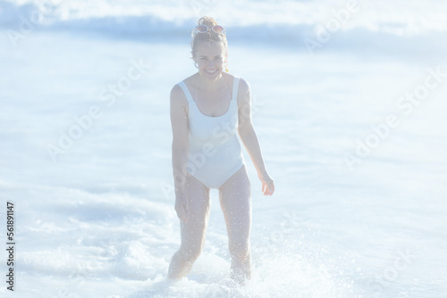happy elegant female in white swimsuit at beach having fun time